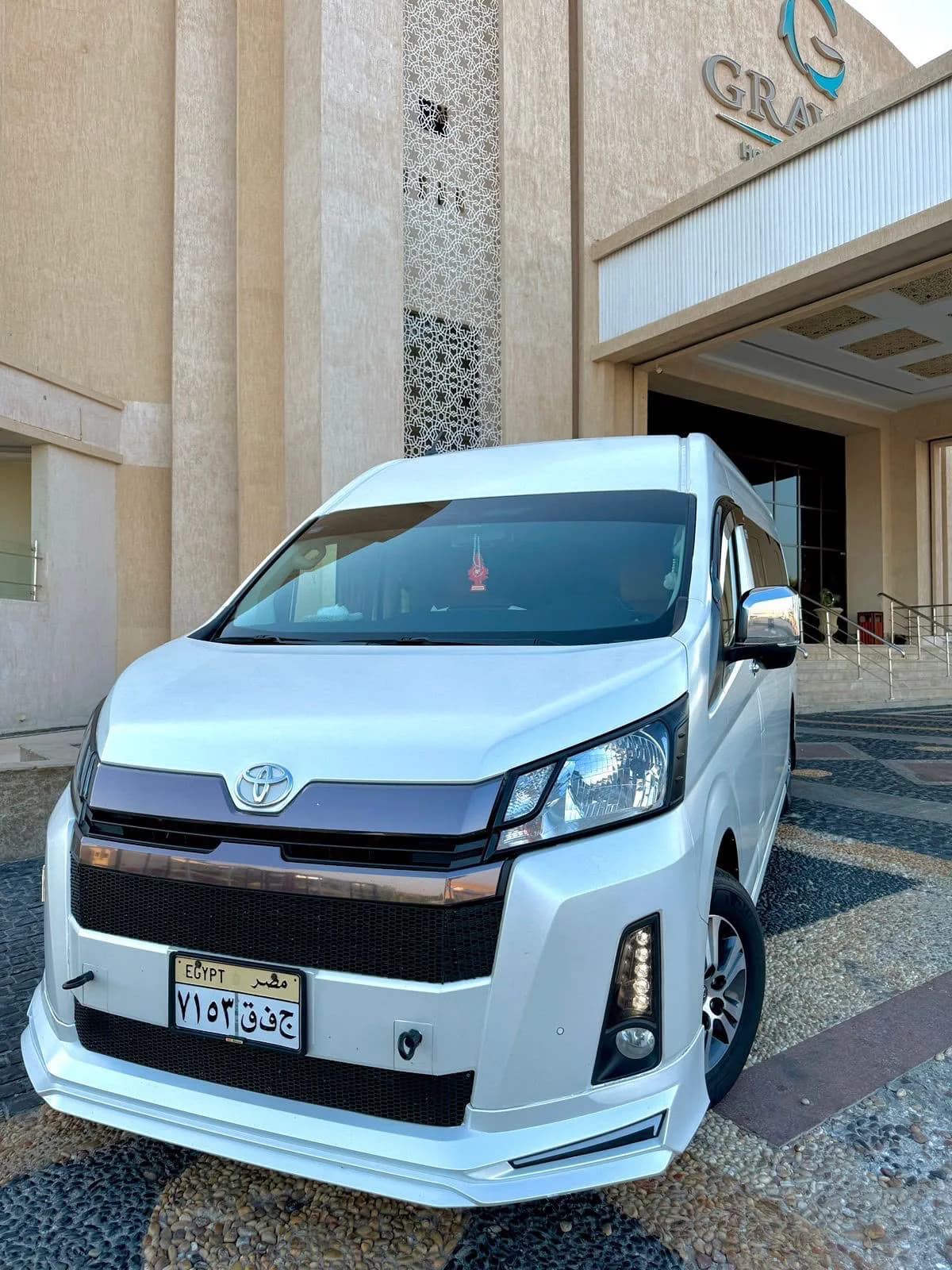 White VIP minibus used for the Cairo excursion, parked outside a Hurghada hotel