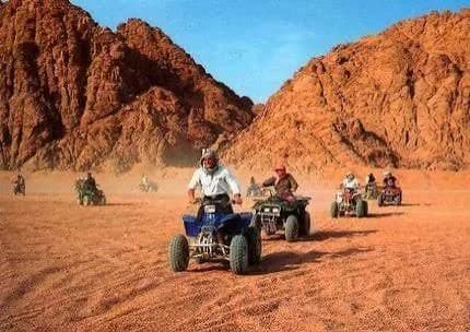 Quad bikes riding through a mountain desert canyon