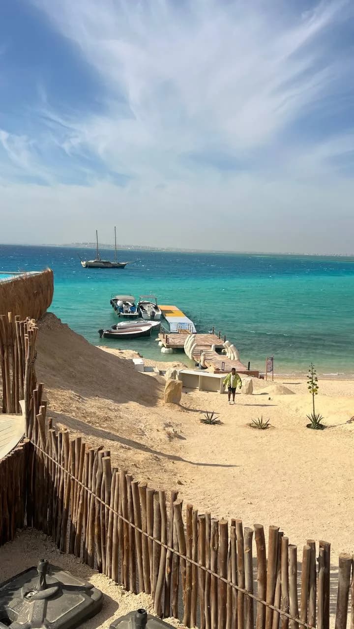 Boats moored at the wooden jetty with turquoise water at Ozirea Island