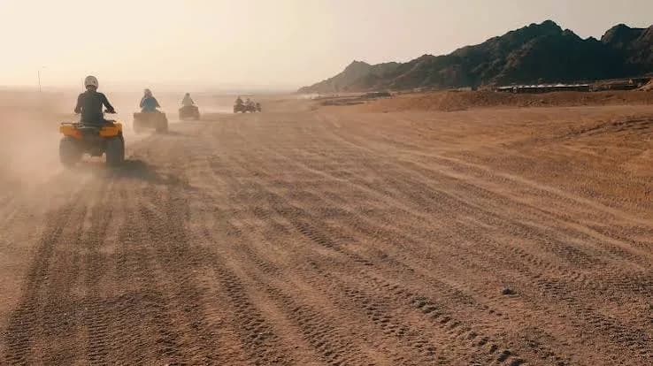 Quad riders crossing the desert at dusk