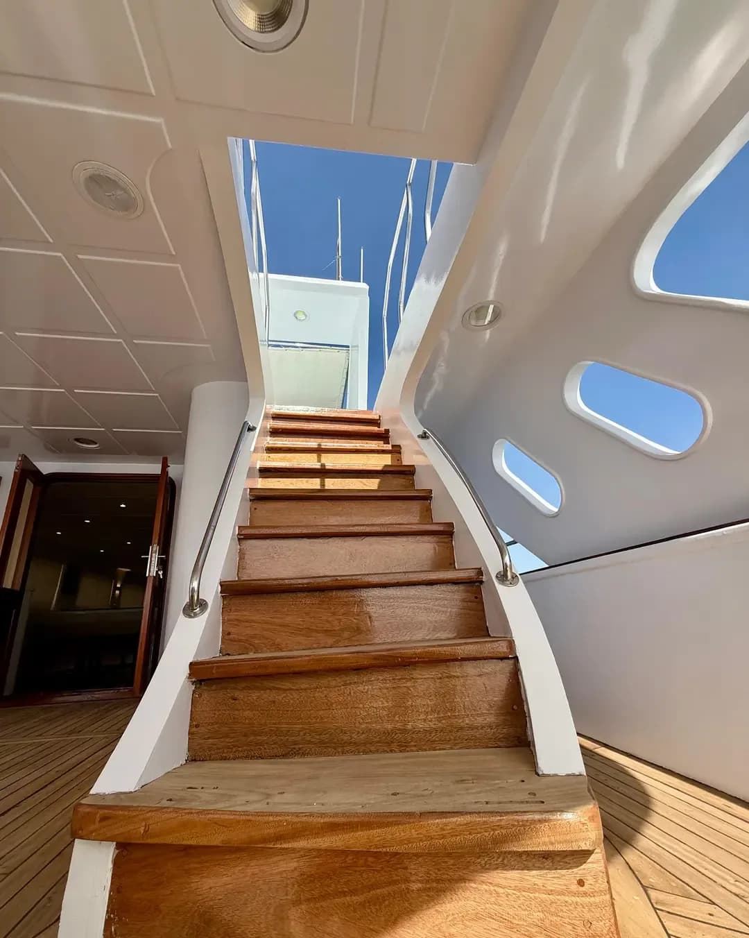 Wooden staircase leading to the upper deck of the cruise boat