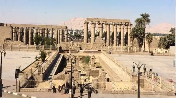 The colonnade of Luxor Temple, with ancient columns and statues lit by afternoon sun