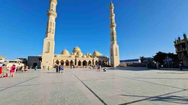 El Mina Mosque exterior with visitors in the courtyard