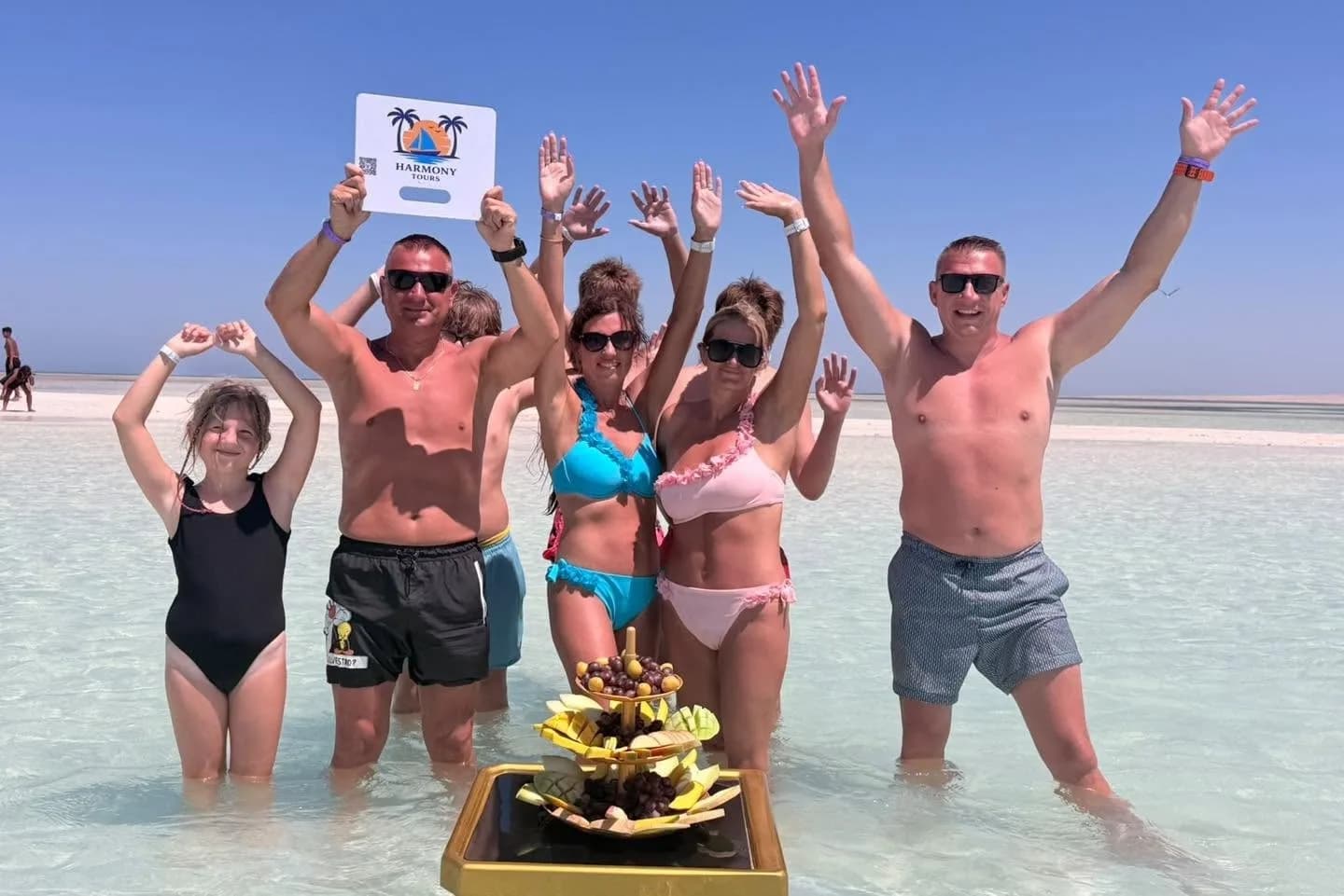 Harmony Tours guests celebrating in the shallow turquoise water at White Island