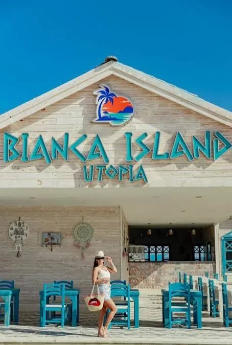 Guest standing in front of the Bianca Island Utopia beach bar building