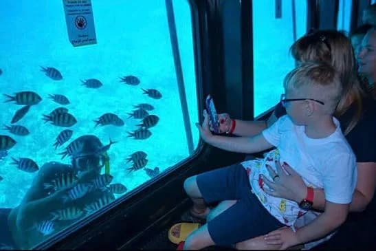 Family watching fish through the Seascope underwater window