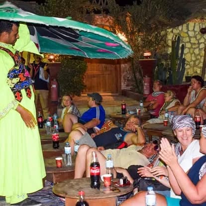 Bedouin dancer performing under a lit umbrella at the evening dinner show