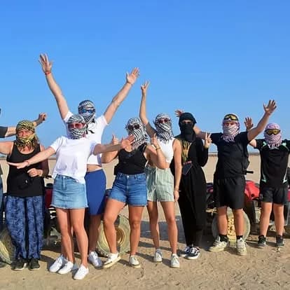 Group of guests in desert scarves posing together after the quad and buggy ride