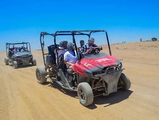 Family riding a buggy through the desert