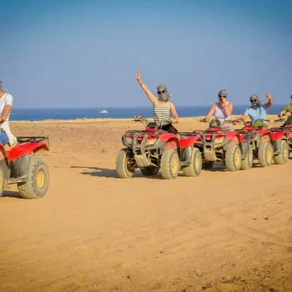 Line of quad bikes riding along the coastline with the Red Sea visible on the Moto Beach Safari